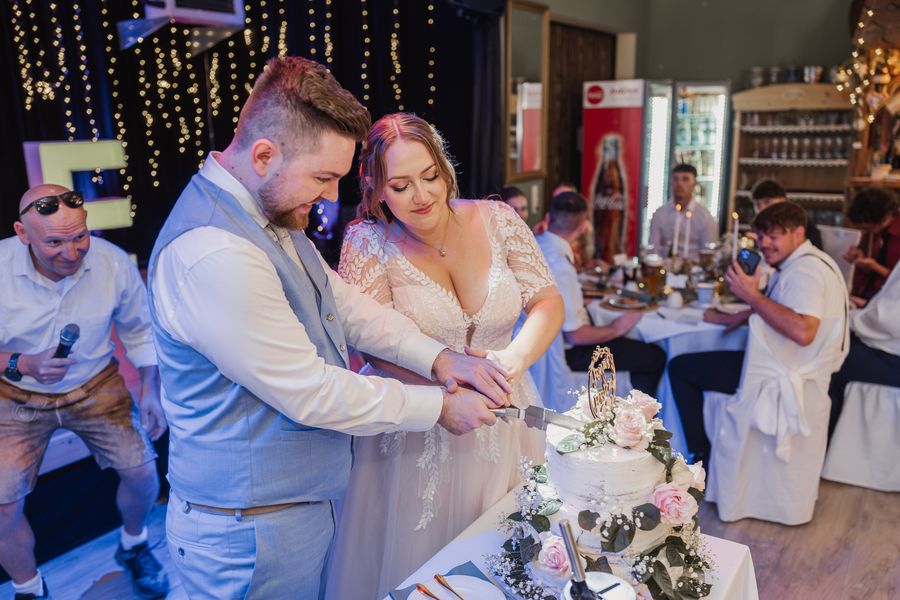 Jessica und Jonas schneiden gemeinsam ihre Hochzeitstorte an