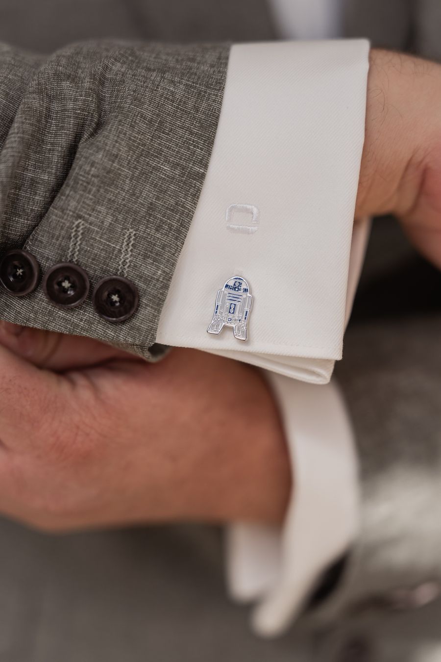 Nahaufnahme von Dominiks Manschettenknopf in Form eines kleinen Roboters
